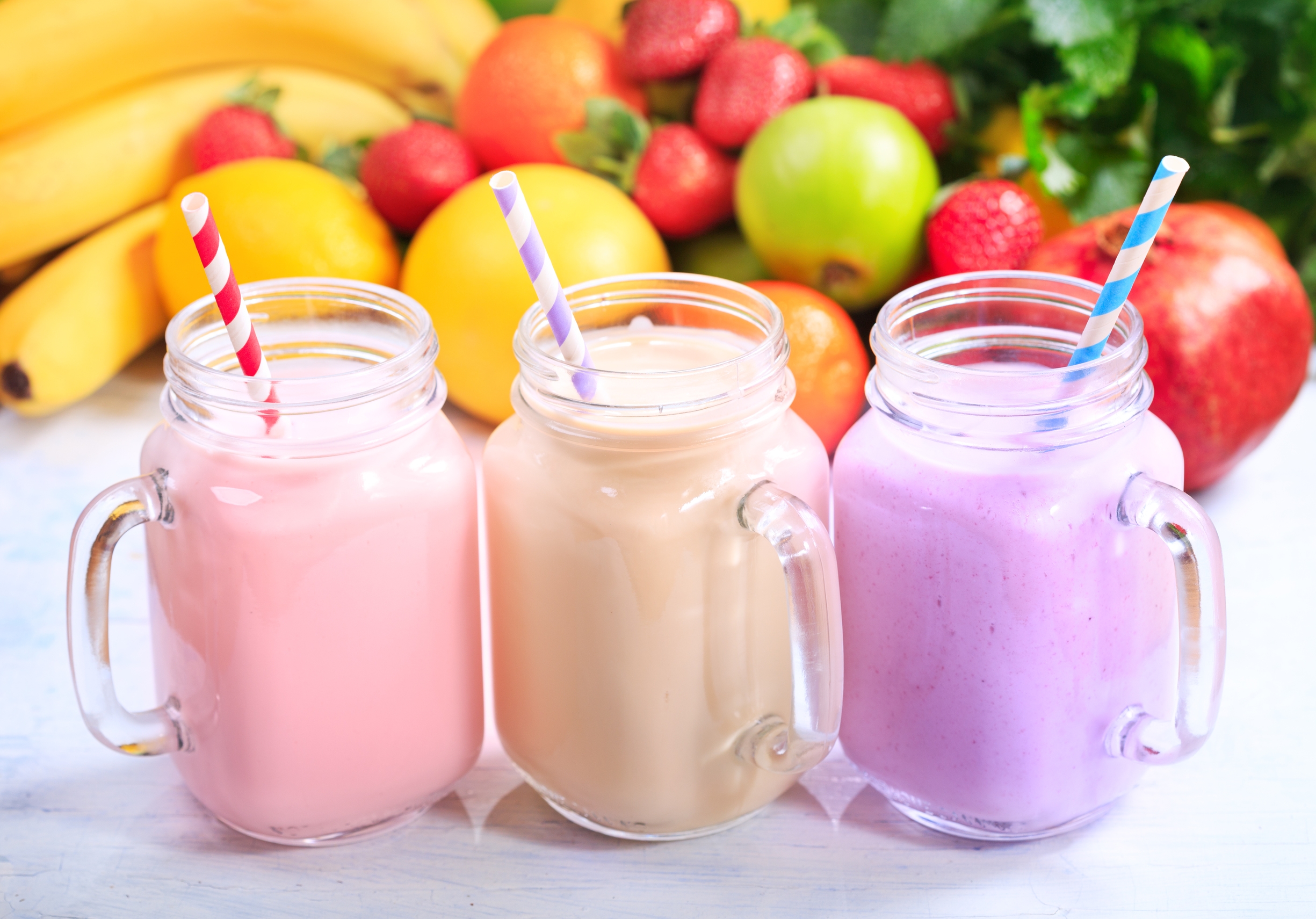 jars of fruit smoothie with striped straws